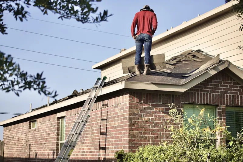 Professional roofer working on a residential roof in Woodtick Road